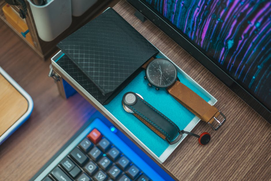A stylish desktop setup featuring a watch, wallet, and keyboard, ideal for modern workspaces.