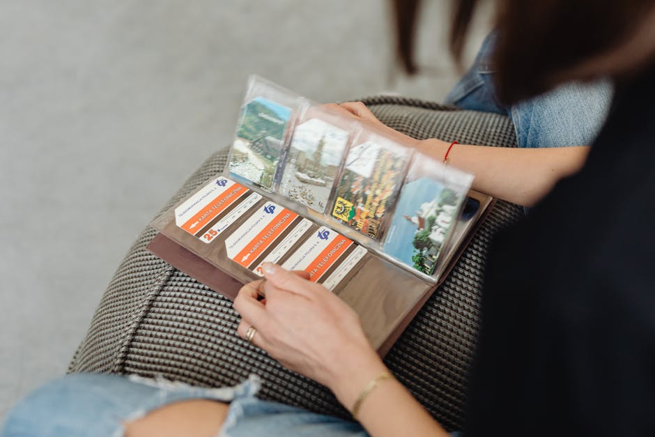 A person flipping through a vintage photo album filled with postcards.