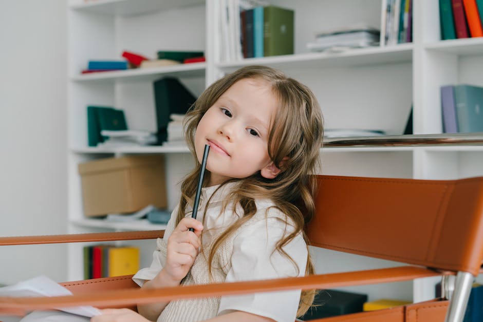 Adorable girl posing with a pencil in a modern home office setting, showcasing creativity and thoughtfulness.