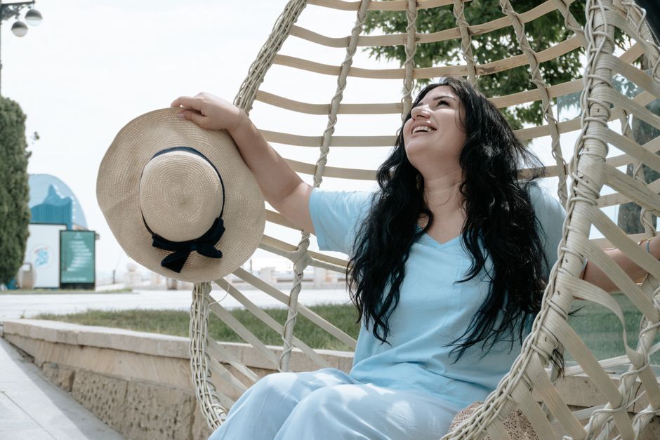 Woman in a blue dress and sunhat enjoys a summer day in Baku, Azerbaijan.