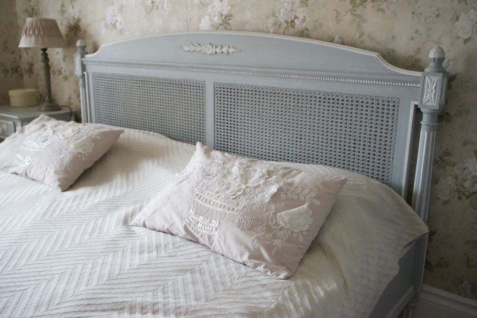 Old-fashioned bedroom with a retro bed and embroidered pillows.