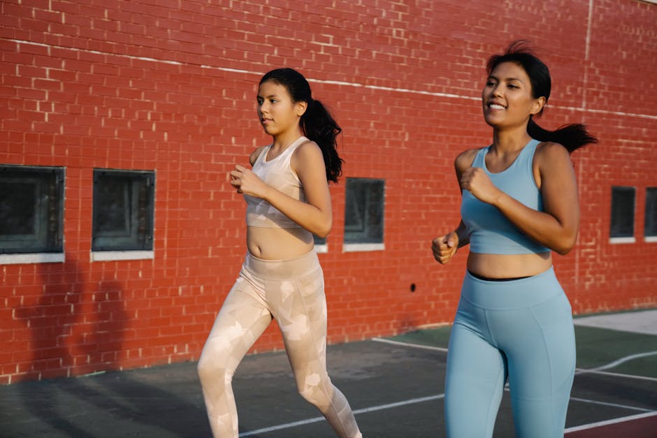 Two young women jogging outdoors in activewear, promoting fitness and healthy living.
